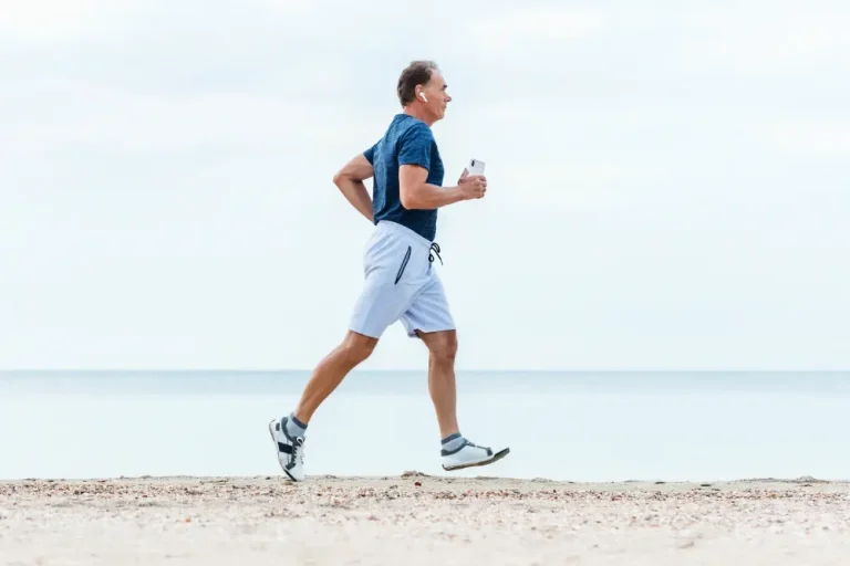 Active older man jogging along the beach, symbolizing the benefits of bioidentical hormone therapy for men in maintaining energy and vitality.