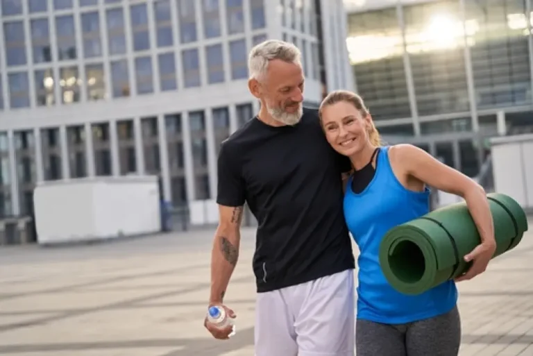 Smiling mature couple in workout gear, post-fitness, showing health after hormone therapy for men Boca Raton