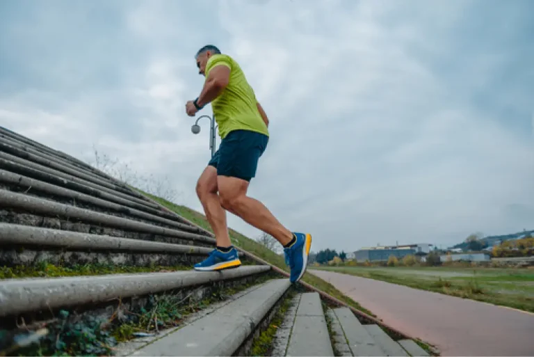 Middle-aged man running up stairs outdoors, symbolizing increased energy and vitality with Bioidentical Hormone Therapy