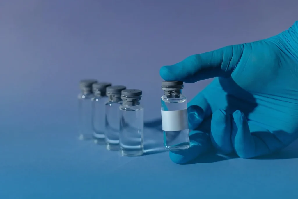 Medical professional holding a testosterone injection vial representing monthly TRT treatment cost