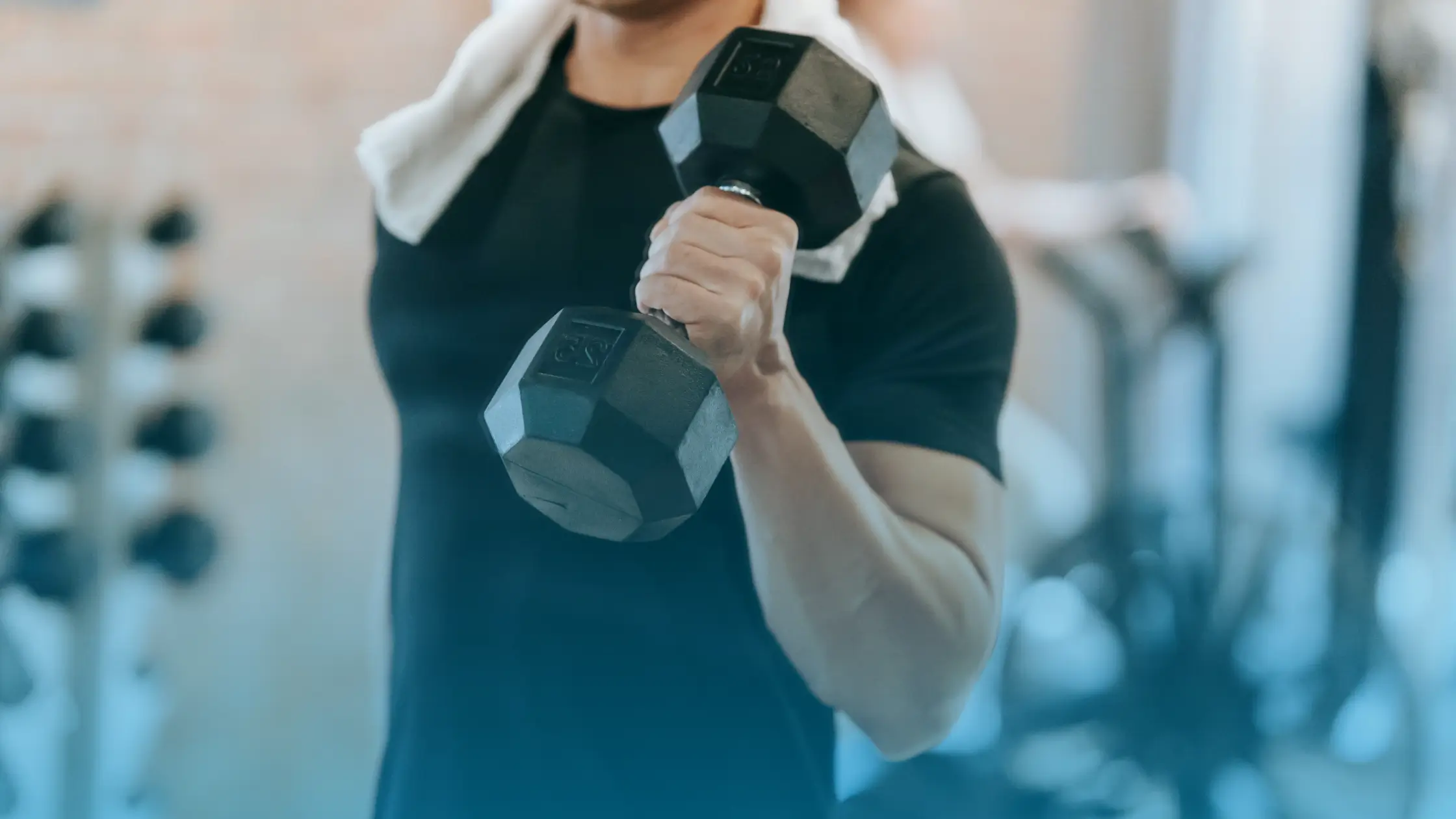 Man lifting weights in a gym during strength training workout representing testosterone therapy and muscle health