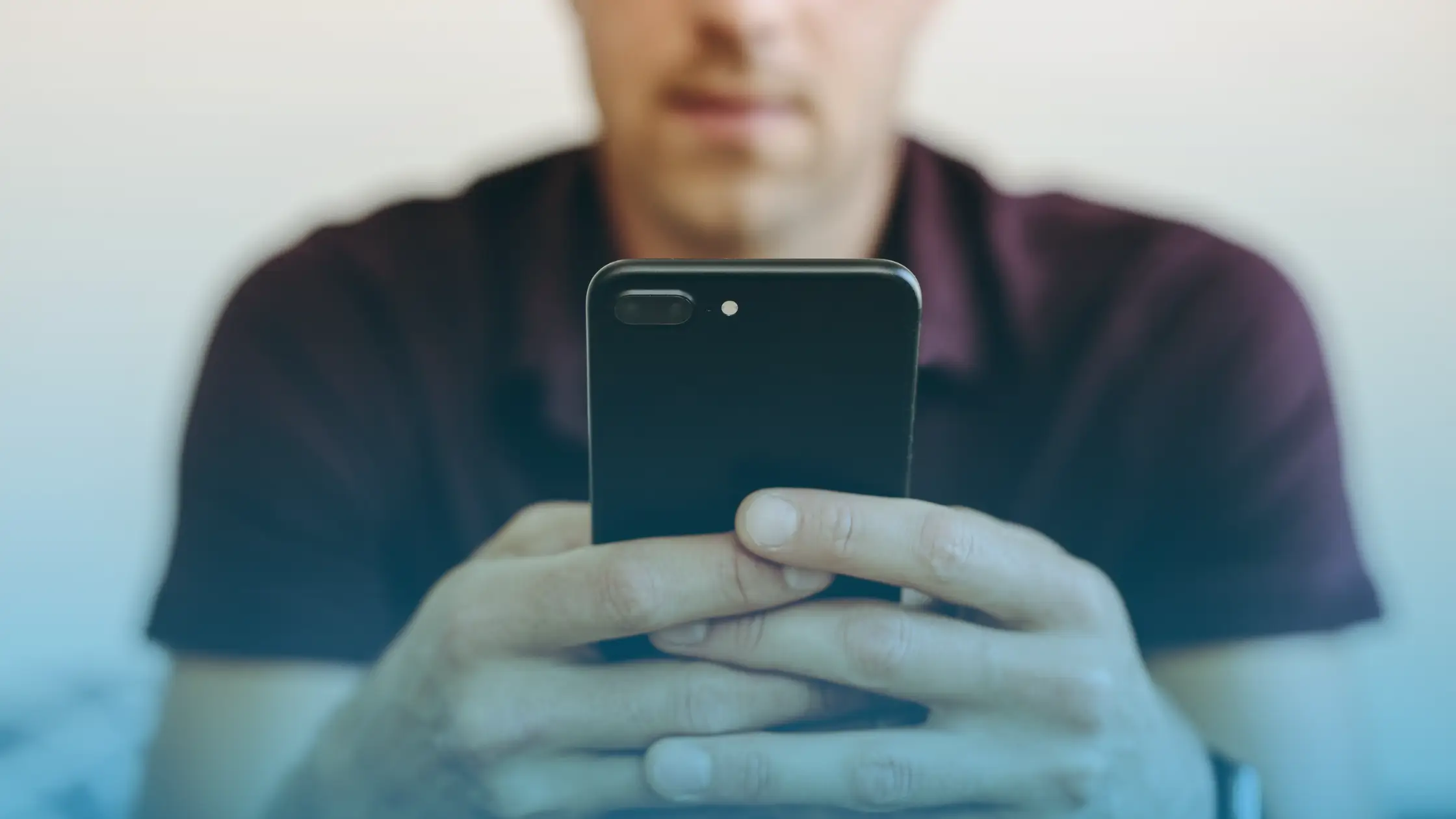 Man using a smartphone to manage online testosterone therapy and virtual hormone health consultation