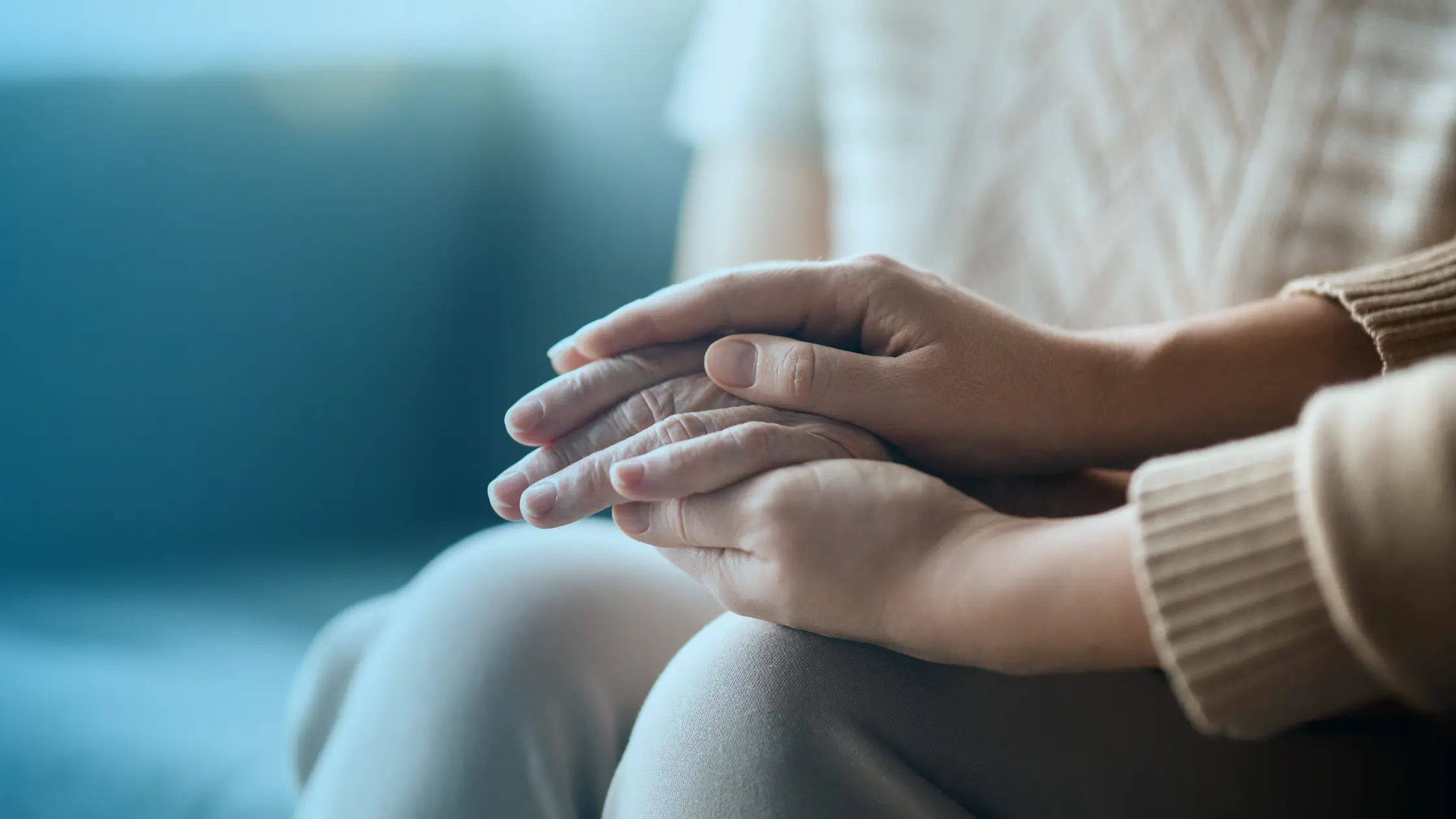 One person holding another person’s hand in comfort and emotional support during depression and hormone imbalance treatment