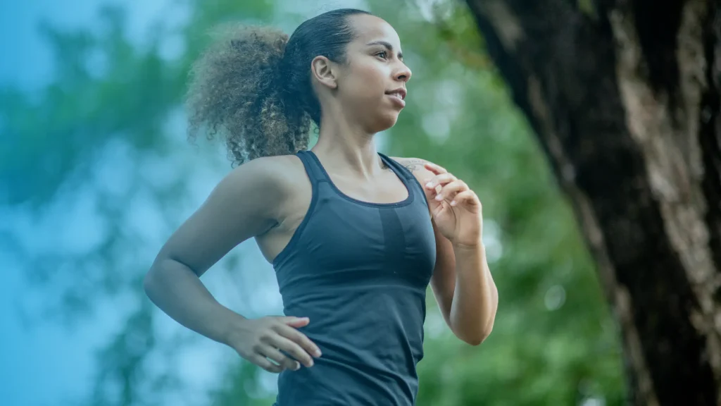 Woman running outdoors in nature representing energy, wellness, and hormone balance for women
