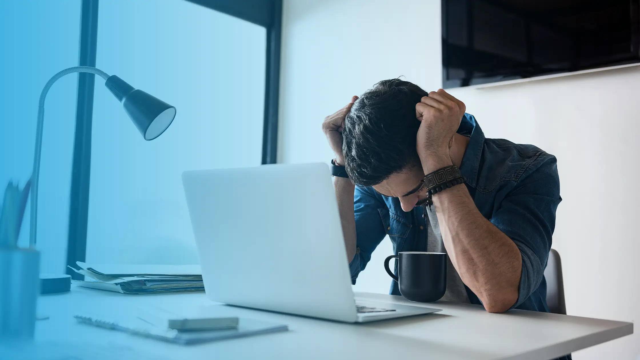 Exhausted man at desk showing signs of hormonal imbalance and fatigue that may require hormone replacement therapy in the USA