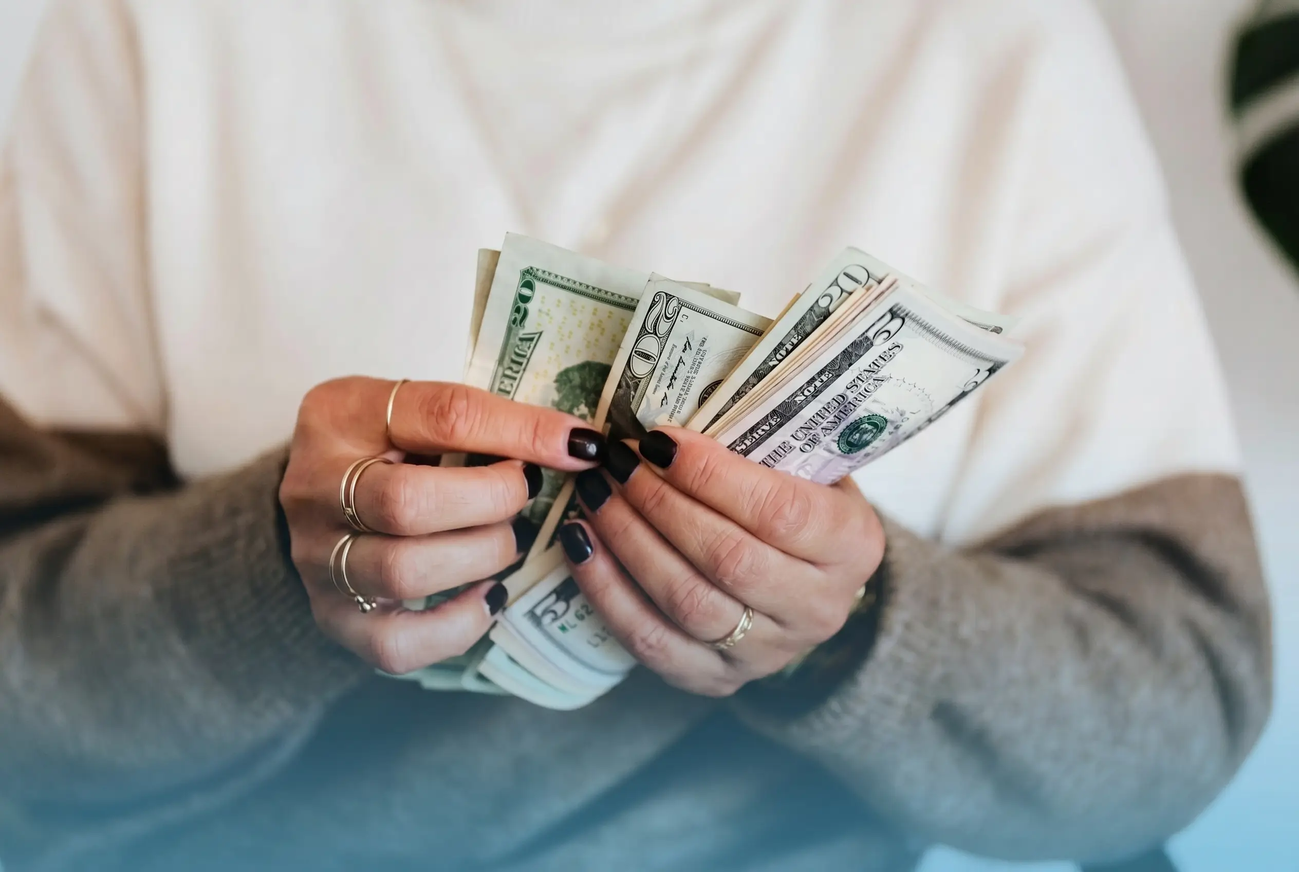 Woman counting cash while budgeting for hormone replacement therapy cost in the USA