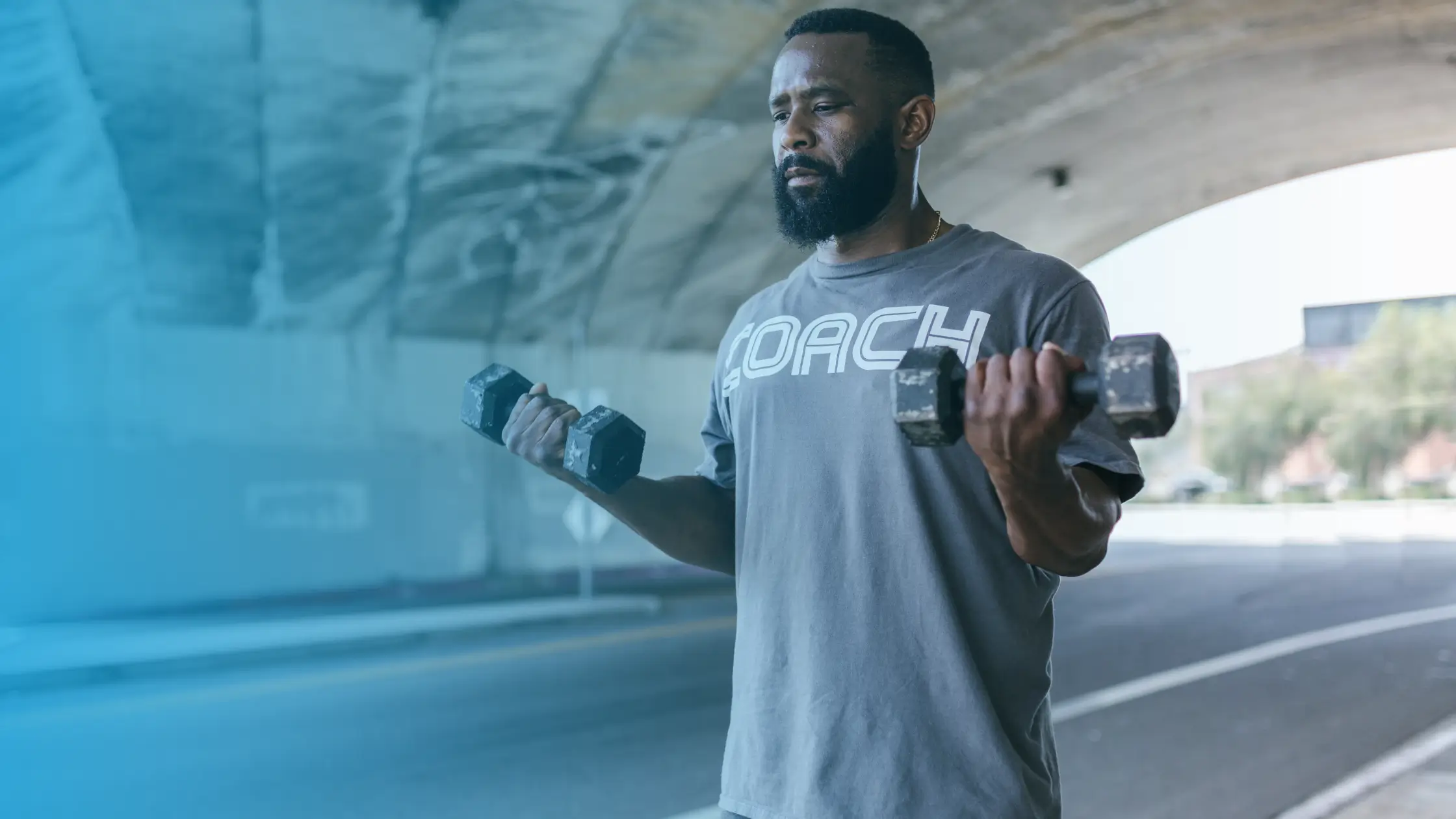 Man in a gym holding dumbbells during strength training and muscle-building workout