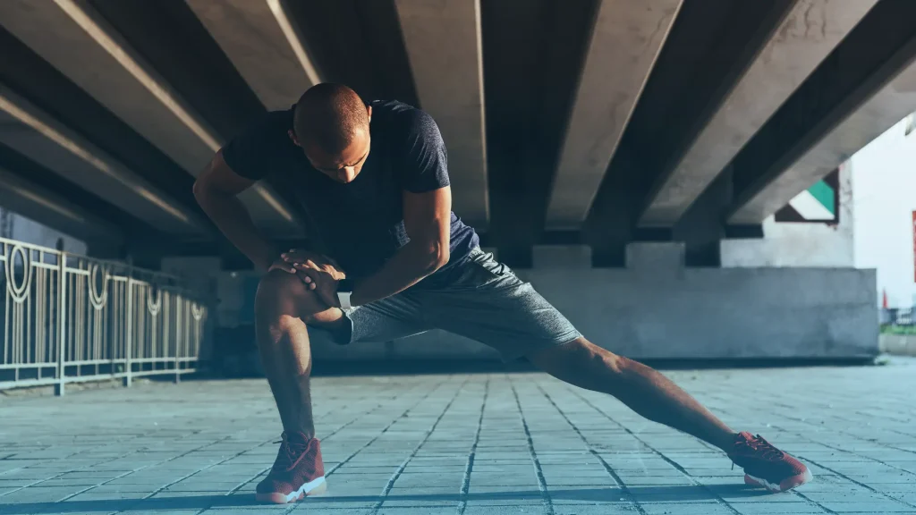 Athletic man stretching outdoors representing muscle recovery and BPC-157 peptide therapy benefits